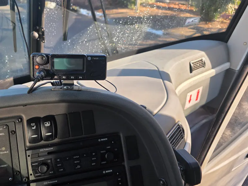 HearClear mobile radio mounted on a charter bus dashboard