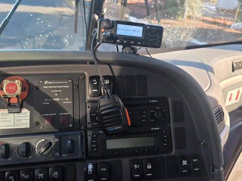 HearClear speaker mic hanging beside the bus dashboard controls